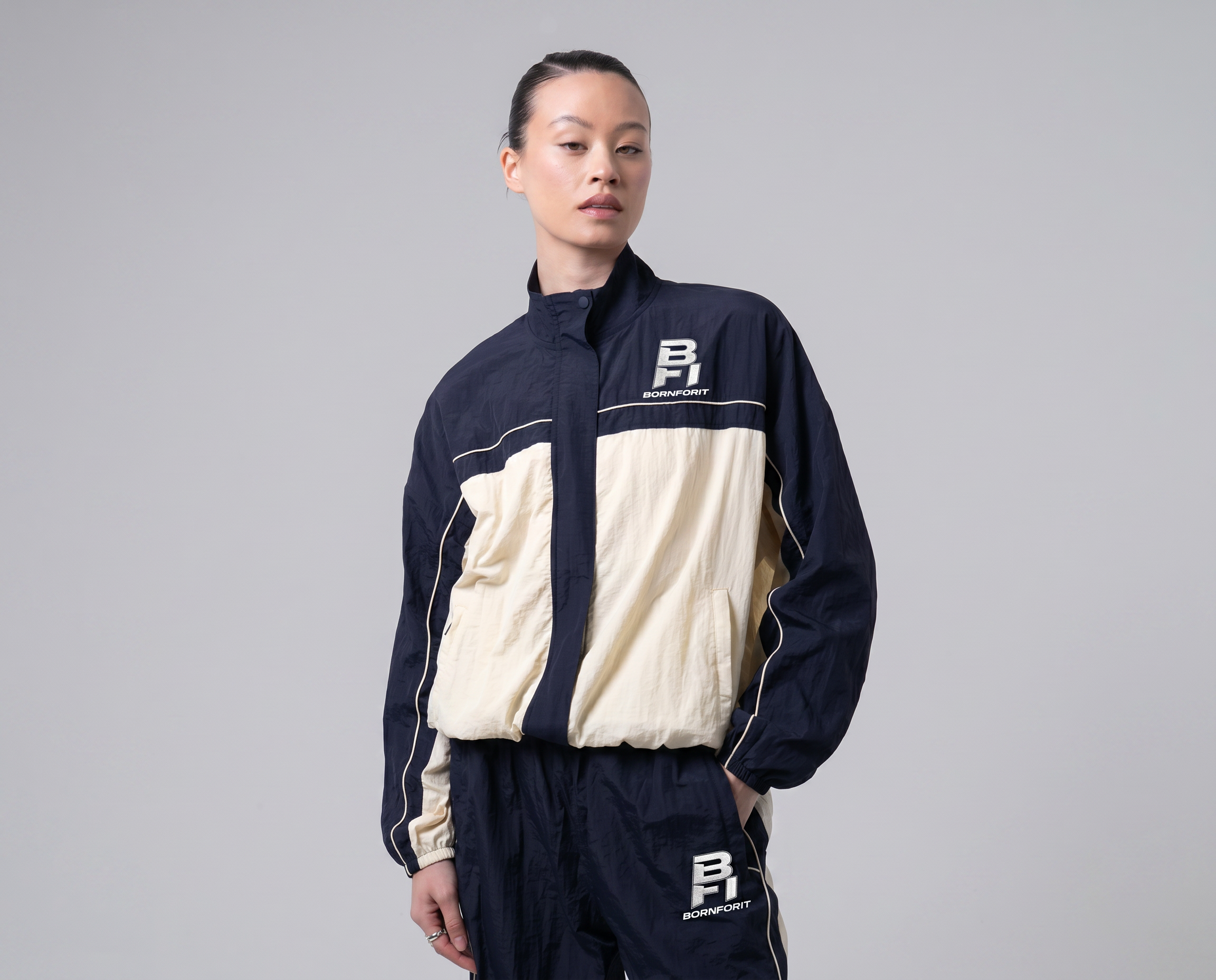 Women's BFI Nell Track Jacket navy cream color-blocked nylon shell with adjustable hem and zip pockets